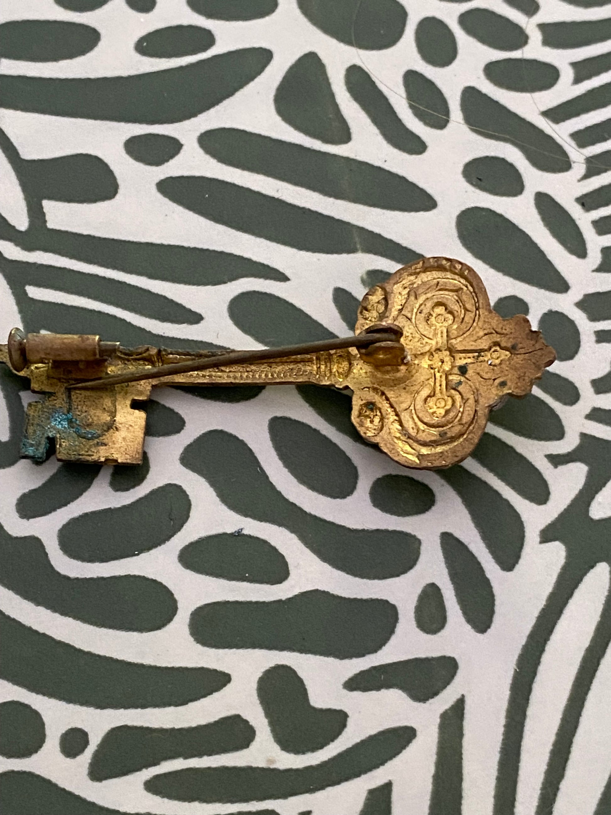 Broche ancienne en métal léger. Clef.