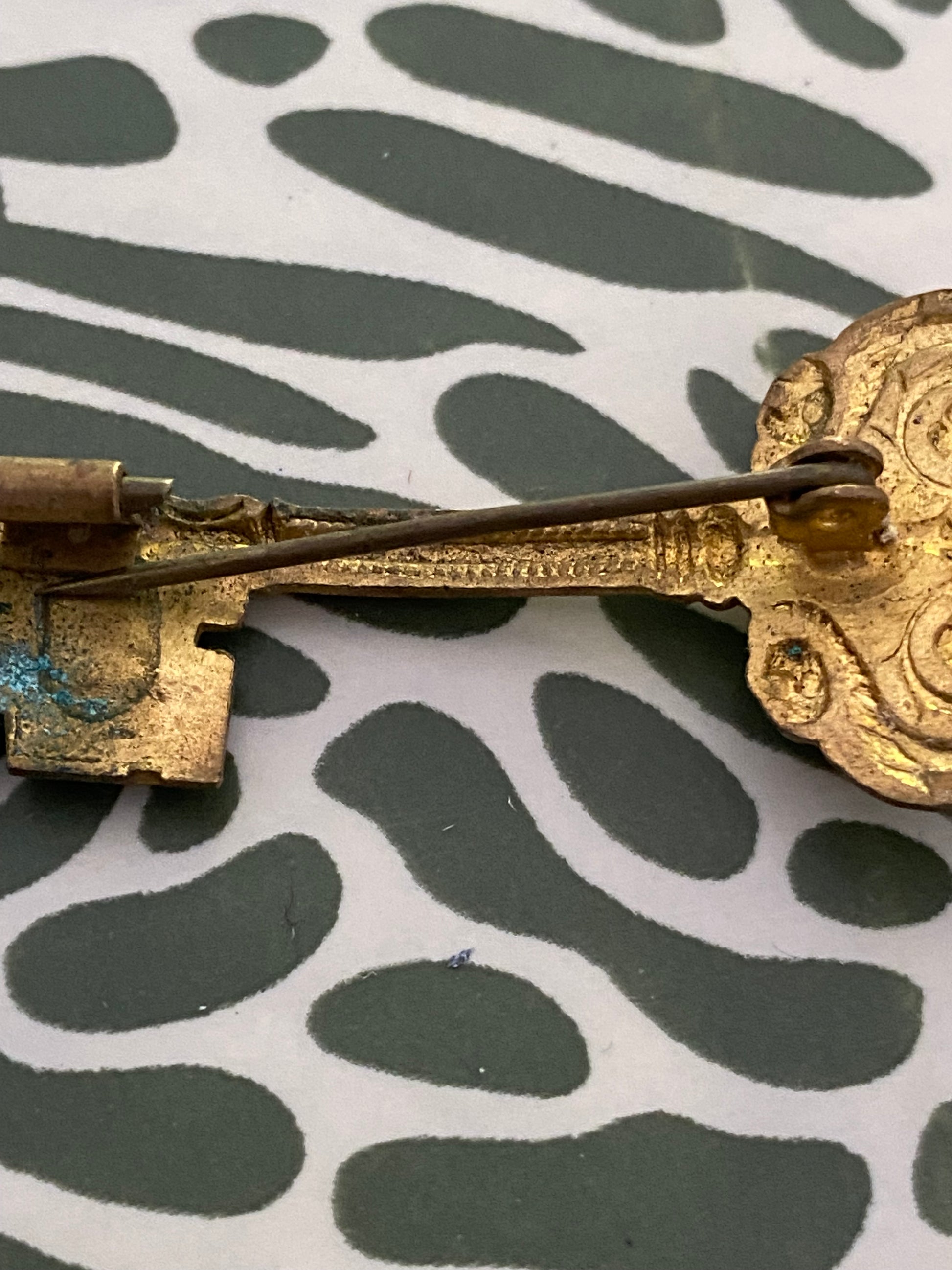 Broche ancienne en métal léger. Clef.